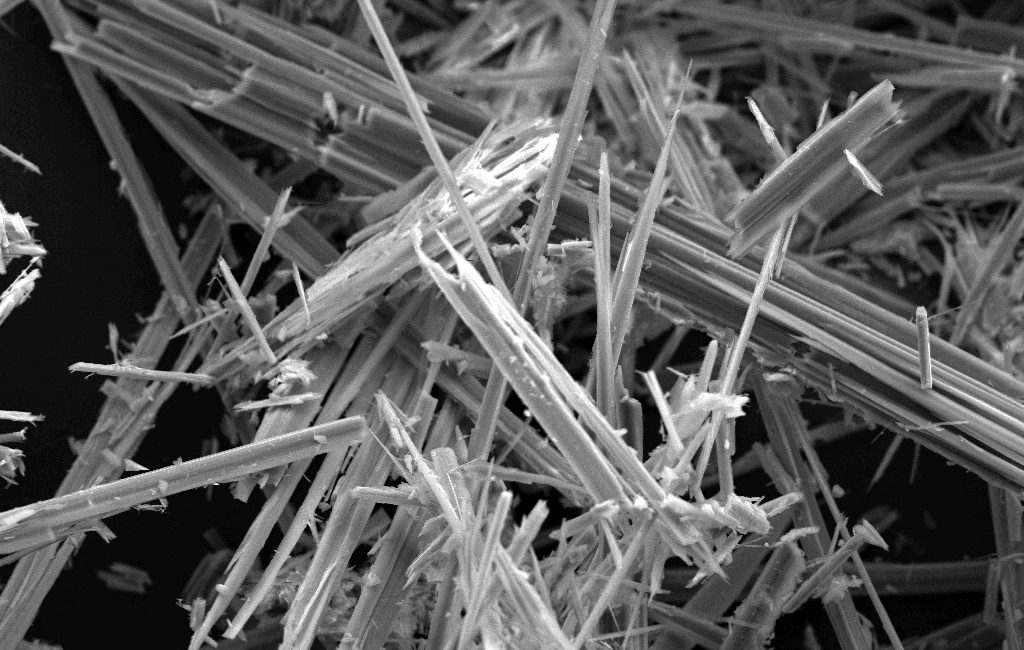 Close-up of microscopic asbestos fibres showcasing their intricate needle-like structure in black and white